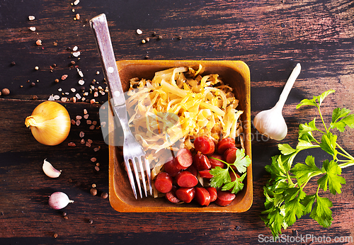 Image of A bowl with Bratwurst and Sauerkraut as side dish - traditional German food