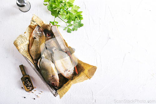 Image of raw fish on wooden tray