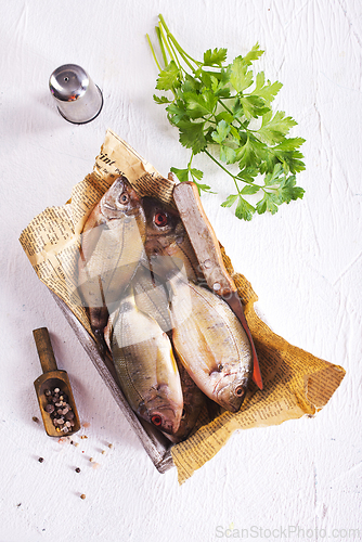 Image of raw fish on wooden tray