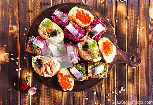 Image of Cocktail canapes with herring, cream cheese and caviar on rye bread