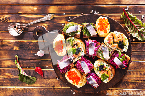 Image of Cocktail canapes with herring, cream cheese and caviar on rye bread