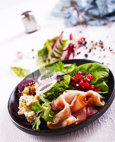 Image of bacon with cheese on green salad