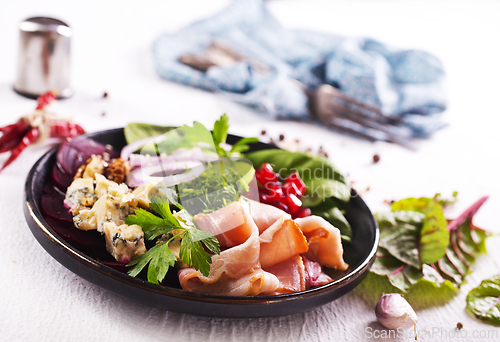 Image of bacon with cheese on green salad
