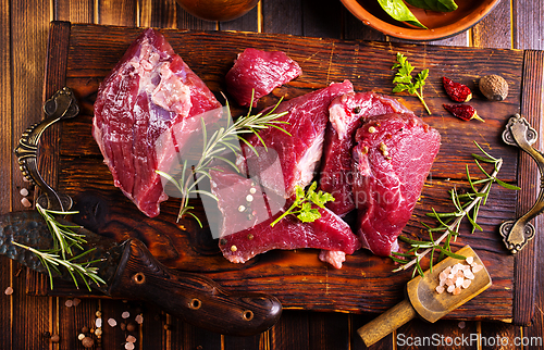 Image of Raw meat with herbs and garlic, marble meat. Wooden background. Top view.