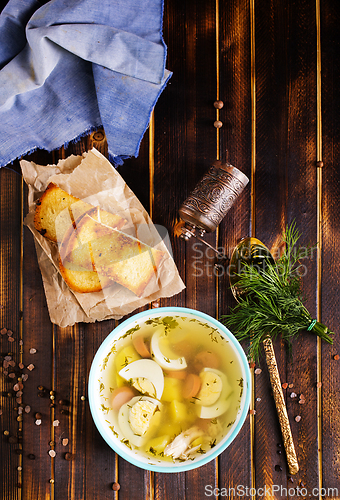 Image of Egg drop soup with meat in white porcelain bowl on wooden table. Fresh soup with eggs and vegetable