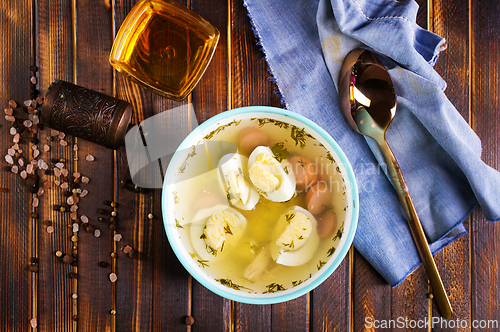 Image of Egg drop soup with meat in white porcelain bowl on wooden table. Fresh soup with eggs and vegetable