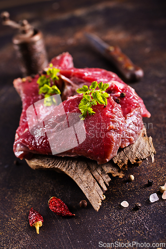 Image of Raw meat with herbs and garlic, marble meat. Wooden background. Top view.