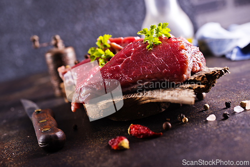 Image of Raw meat with herbs and garlic, marble meat. Wooden background. Top view.