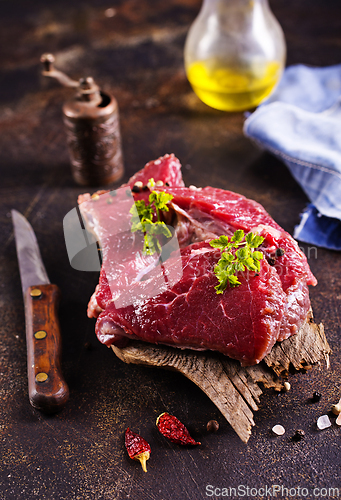 Image of Raw meat with herbs and garlic, marble meat. Wooden background. Top view.