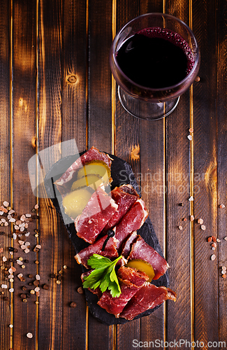 Image of Flat slices of square sandwich ham with herbs. Dark background. Top view. Copy space.