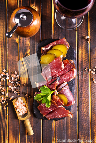 Image of Flat slices of square sandwich ham with herbs. Dark background. Top view. Copy space.