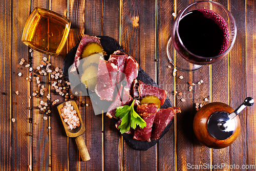 Image of Flat slices of square sandwich ham with herbs. Dark background. Top view. Copy space.