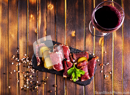 Image of Flat slices of square sandwich ham with herbs. Dark background. Top view. Copy space.