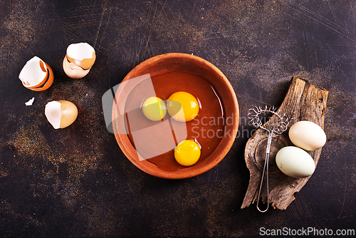 Image of Raw chicken eggs on dark table