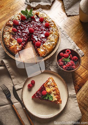Image of Freshly baked raspberry galette with almond flakes