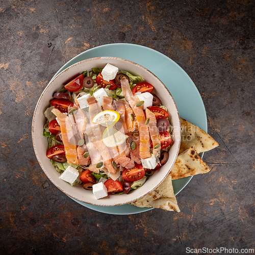 Image of Smoked salmon salad is being served with feta cheese,