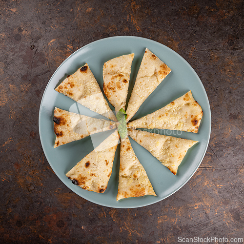 Image of Naan bread slices on blue plate