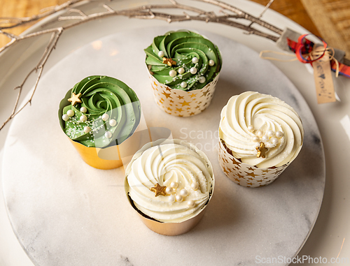 Image of Delicious Christmas cupcakes with festive decorations