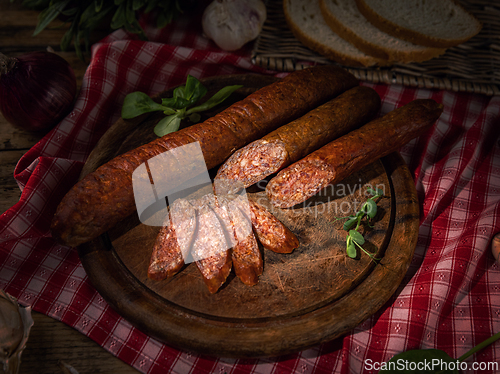 Image of Sliced sausage on wooden board