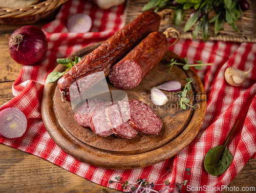 Image of Sliced salami on wooden board