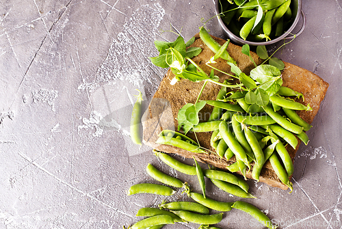 Image of Pods of green peas with leaves. Fresh food background. Top view