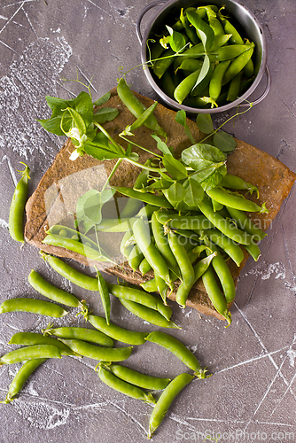 Image of Pods of green peas with leaves. Fresh food background. Top view