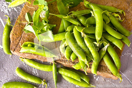 Image of Pods of green peas with leaves. Fresh food background. Top view