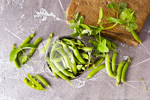 Image of Pods of green peas with leaves. Fresh food background. Top view