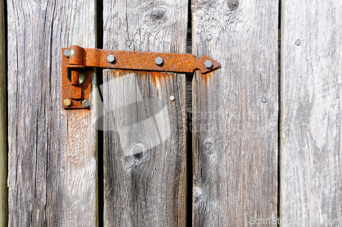 Image of Rustic charm of an aged wooden door with a weathered rusty hinge