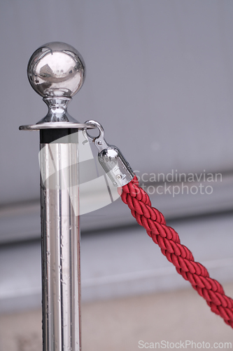 Image of Shiny pole of a red rope fence