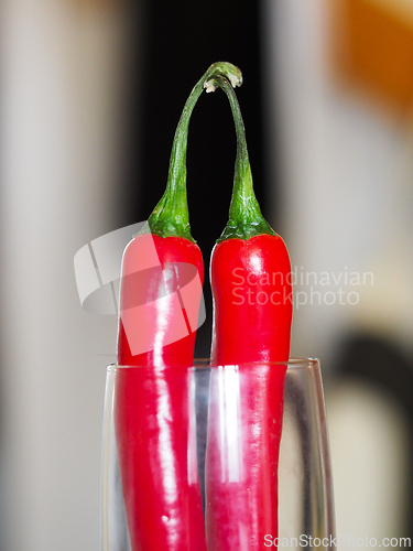 Image of Two red chili peppers in a glass