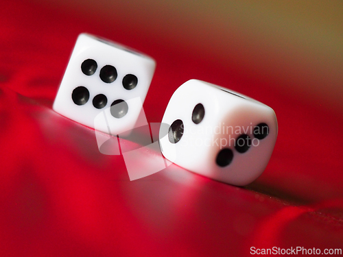 Image of Two white dice on a red table