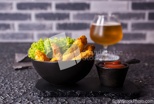 Image of There is a plate of crispy chicken nuggets on the table. Fast food.
