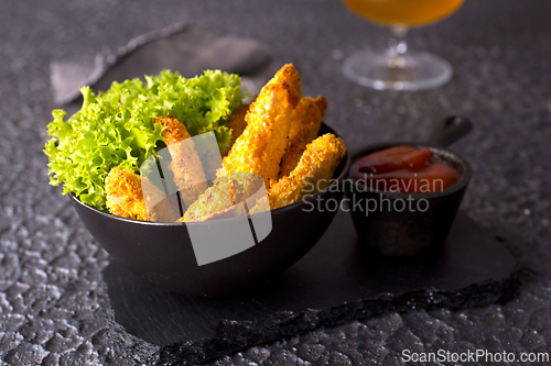 Image of There is a plate of crispy chicken nuggets on the table. Fast food.