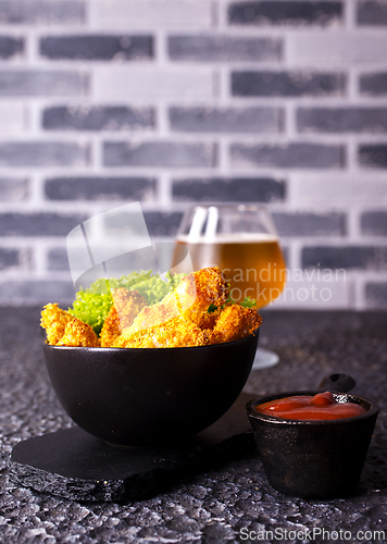 Image of There is a plate of crispy chicken nuggets on the table. Fast food.