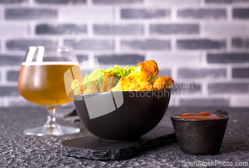 Image of There is a plate of crispy chicken nuggets on the table. Fast food.