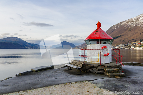 Image of Lighthouse on the tranquil shores of a Norwegian fjord surrounde