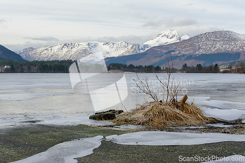 Image of Snow-capped peaks reflect in icy waters as winter embraces the s