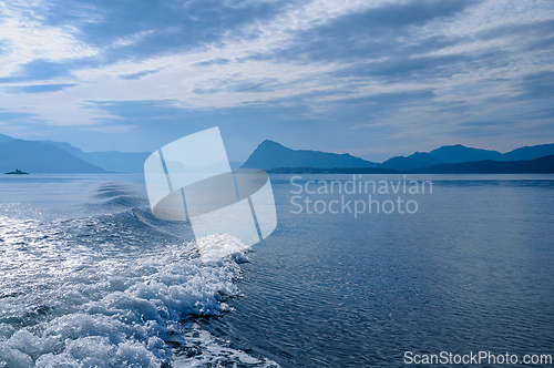 Image of Calm waters reflecting the serene Norwegian landscape under a cl
