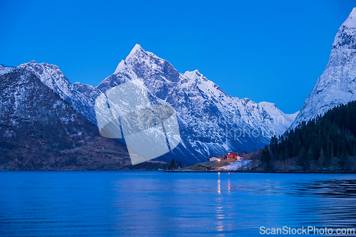 Image of Majestic snow-capped mountains reflect in tranquil waters during