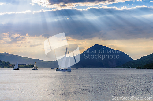 Image of Sailboats glide across serene waters in Norway under a majestic 