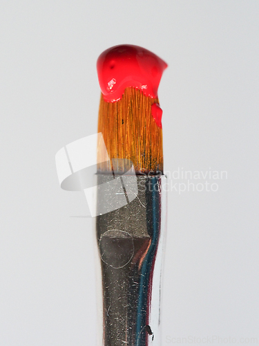 Image of Old paintbrush with red paint