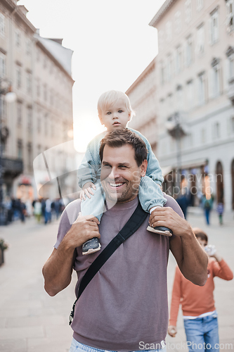 Image of Portrait of smiling father carrying his toddler child piggyback around city on family vacations. Happy father's day.