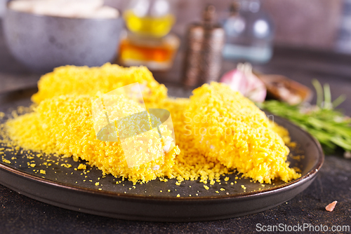 Image of chicken wings with panko in a gray ceramic bowl on a rustic table ready to cooking
