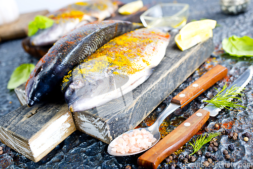 Image of Fresh raw dorado fish cooking with lemon and spice.