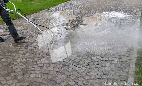Image of Cleaning service worker washing cobblestone