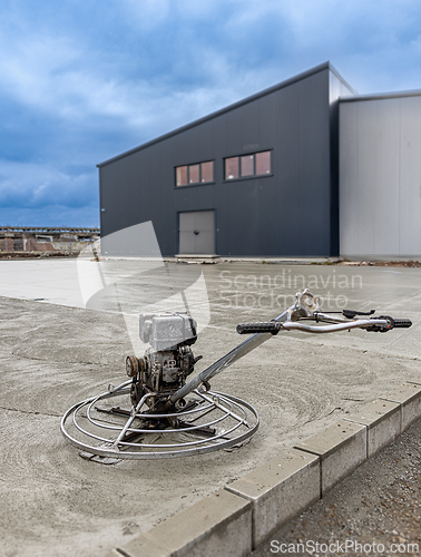 Image of Concrete finishing process using a power trowel machine
