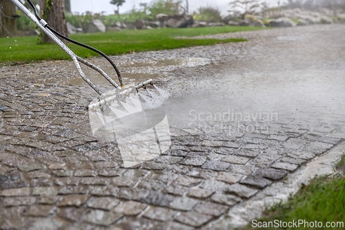 Image of Professional cleaning service worker washing cobblestone