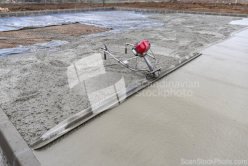 Image of Power screed smoothing fresh concrete surface