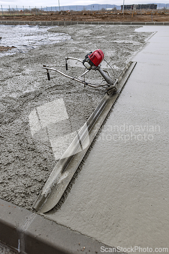 Image of Power screed smoothing fresh concrete surface